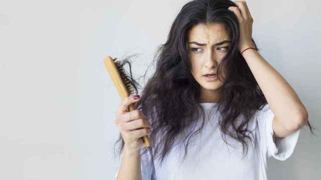 Imagen de archivo mujer con caída de pelo al cepillarse