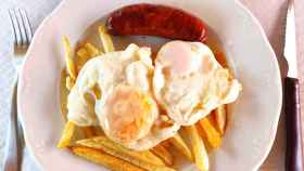 Un plato de patatas fritas con huevo.