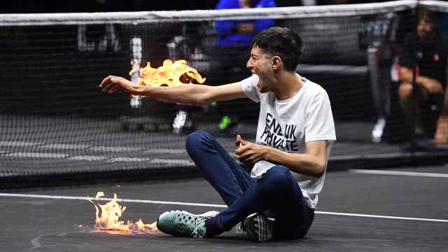 Un manifestante con llamas en su brazo en el O2 Arena durante la Laver Cup