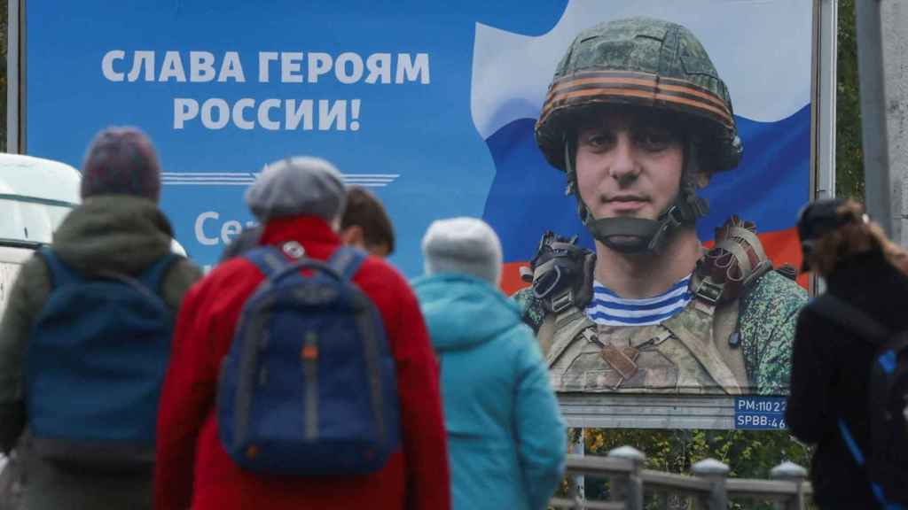 Un cartel de propaganda bélica, junto una parada de tranvía en San Petersburgo, dice: ¡Gloria a los héroes de Rusia!.