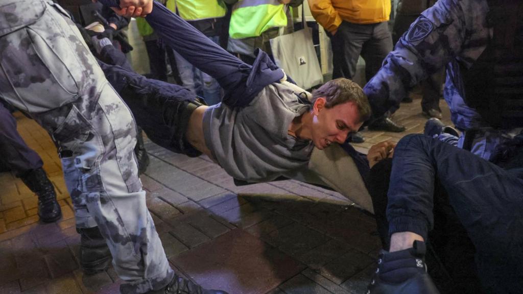 Russian policemen detain a young man during a demonstration against the mobilization of reservists ordered by Vladimir Putin, in Moscow.