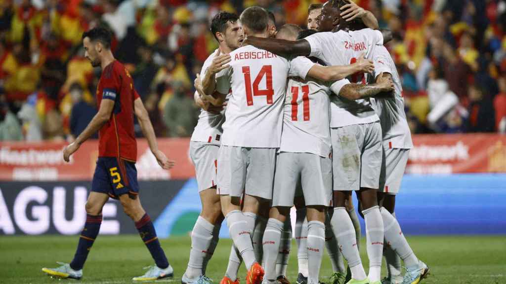 Sergio Busquets pasa junto a los jugadores de Suiza mientras celebran un gol