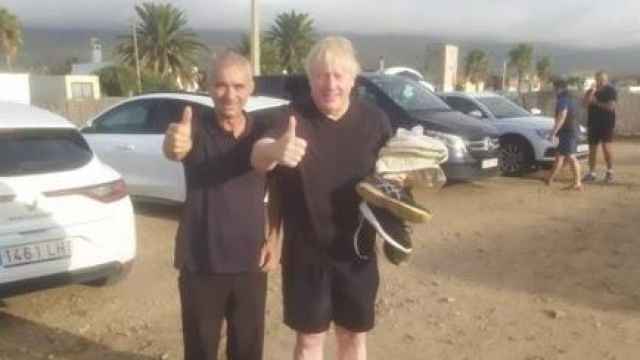 Boris Johnson en la playa de Bolonia (Tarifa) este domingo, con Antonio, un empleado del Hostal Ríos.