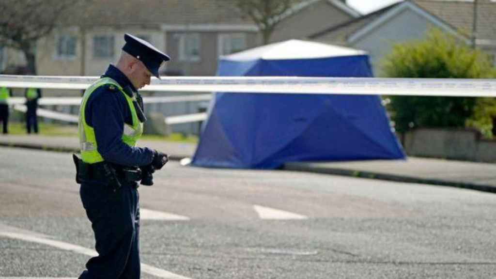 Un oficial de Garda patrulla un cordón en la escena en el área de Deanstown Avenue de Finglas, Dublín, donde un hombre de unos 20 años fue declarado muerto en las primeras horas de esta mañana después de que Gardai y los servicios de emergencia lo encontraran con una herida de bala.