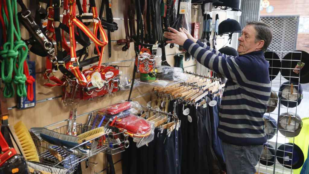 Un comerciante muestra sus productos en la tienda que regenta en León
