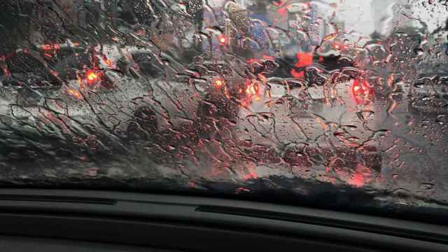 Un coche circulando durante un día de lluvia.