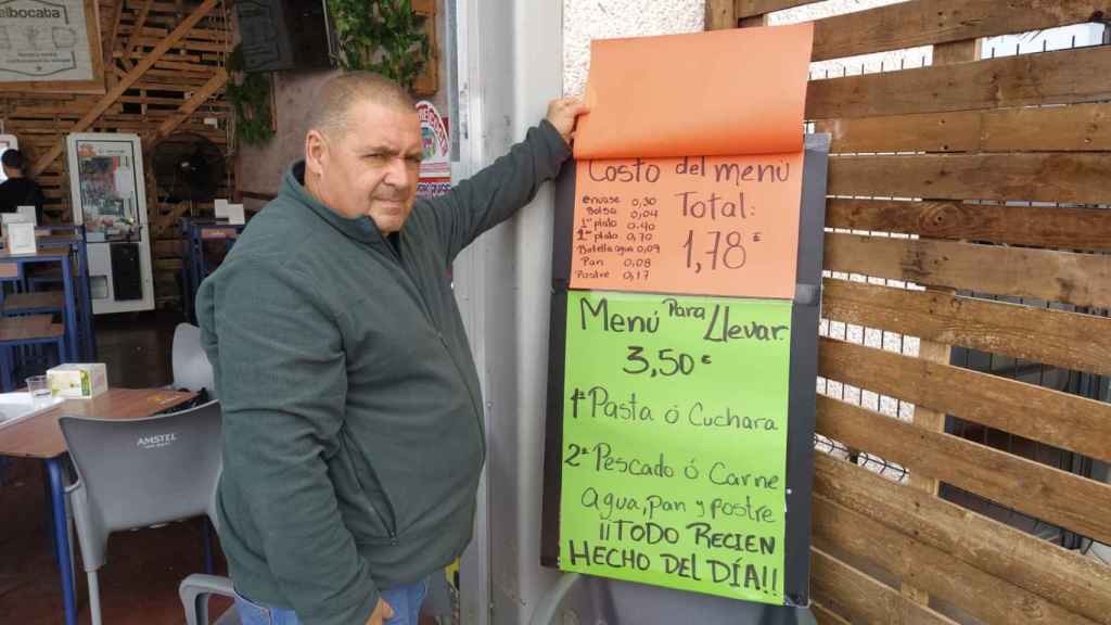 Carlos Moreno, enseñando el cartel que asegura que el costo del menú es de 1,78 euros.