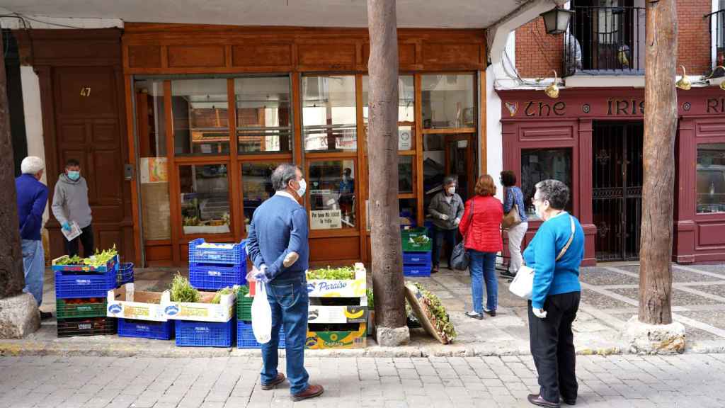 Vecinos de un pueblo de Castilla y León hacen cola para compar en un establecimiento
