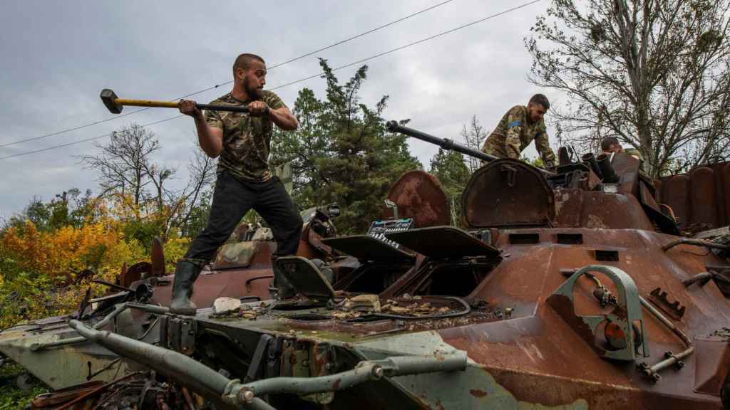 Ukrainian soldiers dismantle a captured Russian armored vehicle near the city of Izium in the Kharkiv region.