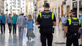 Una pareja de agentes de la Policía de Málaga camina por la calle Larios.