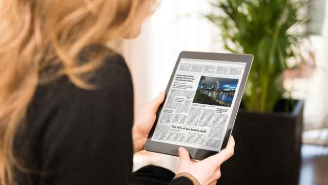 Una mujer lee la prensa en una 'tablet'