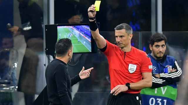 El árbitro Vincic muestra una tarjeta amarilla a Xavi Hernández
