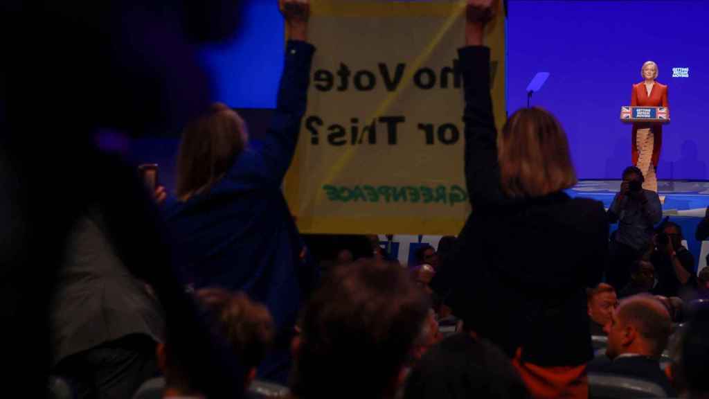 Activistas de Greenpeace se levantan ante Truss con una pancarta: '¿Quién ha votado por esto?'.