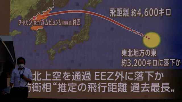 Transeúntes en Tokio frente a una pantalla que informa del lanzamiento de misiles por parte de Corea del Norte.