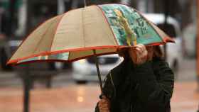 Imagen de archivo de una persona paseando un día de lluvia.