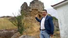 El procurador de UPL en las Cortes, Luis Mariano Santos, junto a una de las torres del castillo de Cerralbo