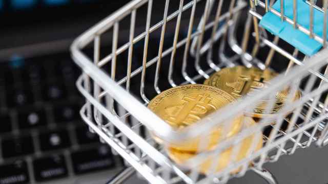 Bitcoins dentro de un pequeño carro de la compra de juguete.