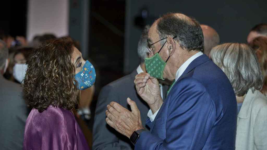 La ministra de Hacienda y Función Pública, María Jesús Montero, conversa con el presidente de Iberdrola, Ignacio Galán, en un acto.