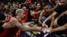 Griezmann regala su camiseta a unos aficionados del Atlético de Madrid en el Metropolitano