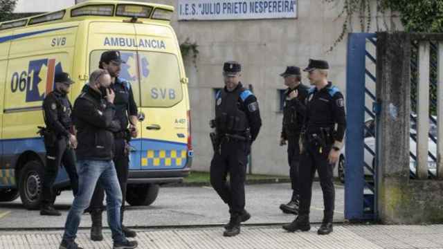 Efectivos de la Policía Local montan guardia en la puerta de entrada del instituto Julio Prieto Nespereira (Ourense), donde ha fallecido un estudiante tras el incidente.