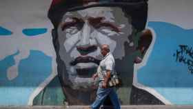 Un viandante pasea ante un mural de Hugo Chávez en las calles de Caracas.
