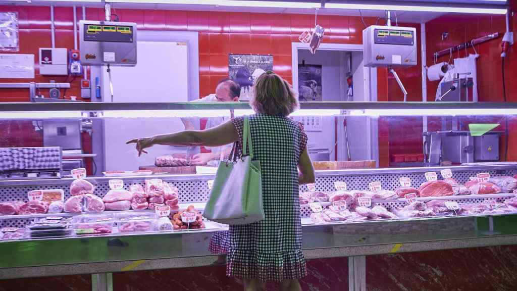 Una mujer compra carne en un supermercado.