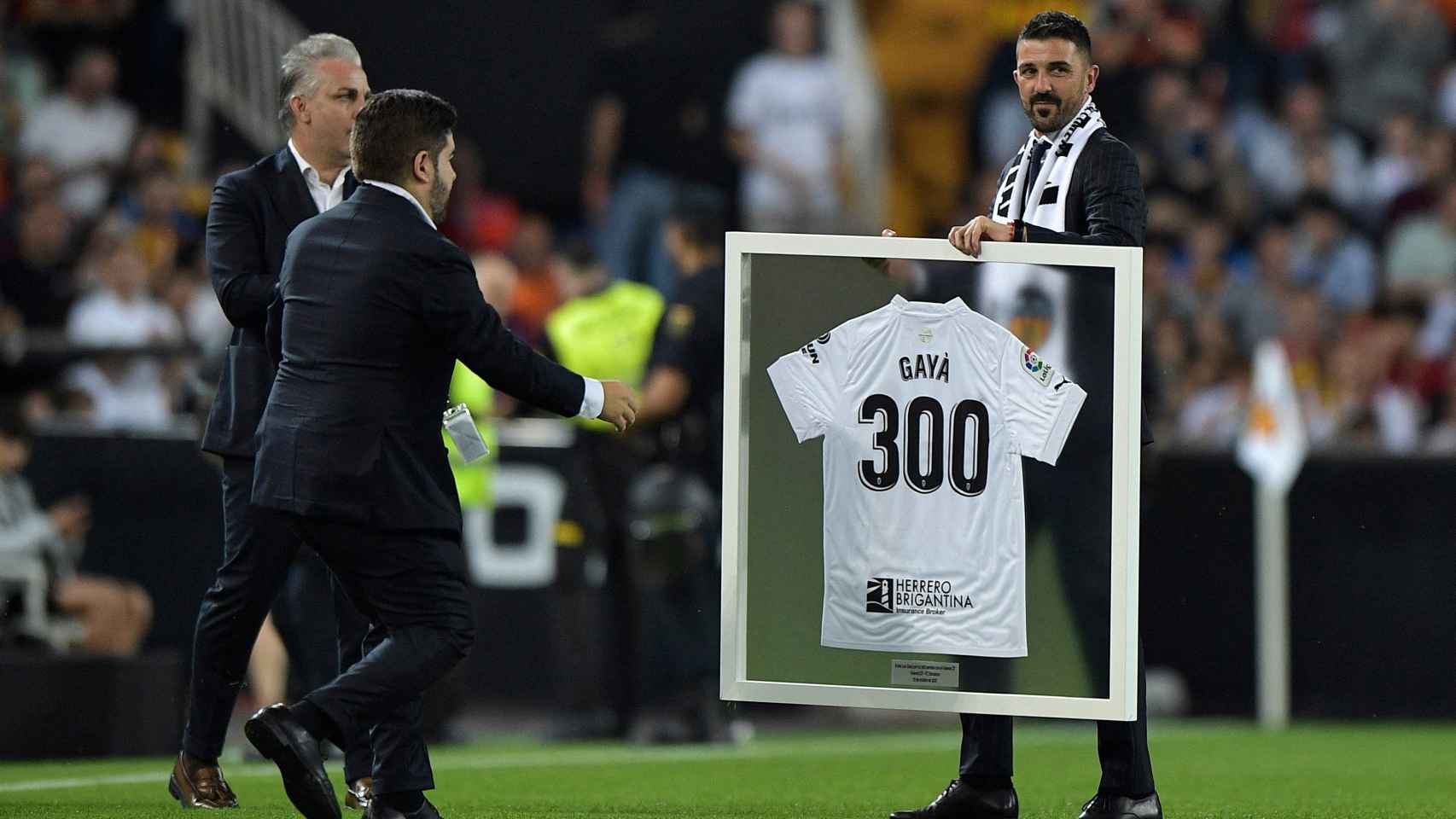 David Villa entrega una camiseta conmemorativa a Gayà por sus 300 partidos con el Valencia