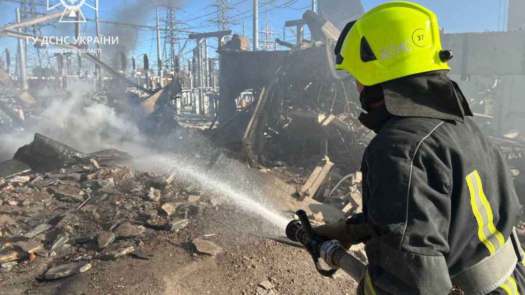 Los bomberos trabajan para apagar un incendio en las instalaciones de infraestructura energética, dañadas por un ataque con misiles rusos en la región de Kiev en Ucrania.