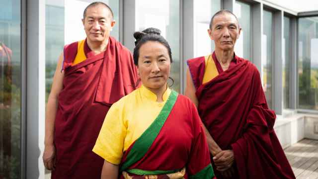 Khadro La acompañada de dos monjes budistas
