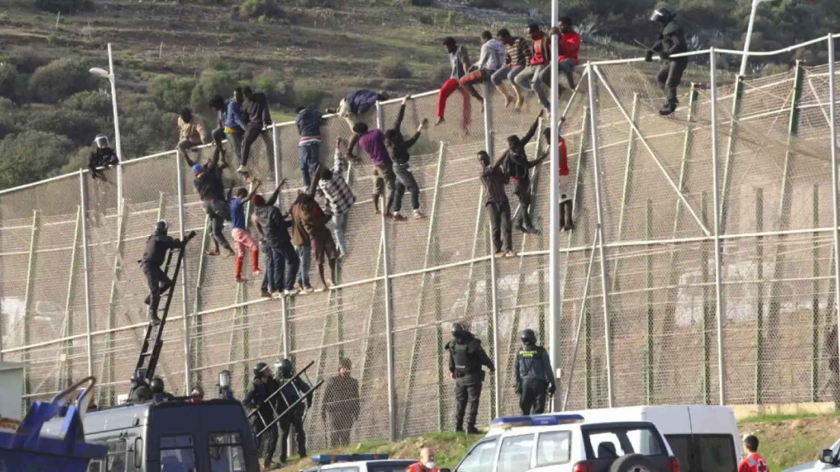Unos 500 migrantes hacen el signo de la victoria tras saltar la valla de Melilla