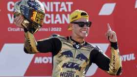 Augusto Fernández, con casco y mono dorado, celebra su título de campeón de mundo de Moto2 en el podio de Cheste.