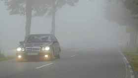 Un coche circulando con niebla.