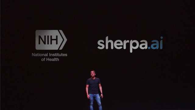 Imagen de Xabi Uribe-Etxebarria, fundador y consejero delegado de Sherpa.ai, delante de los logos de su compañía y del NIH.