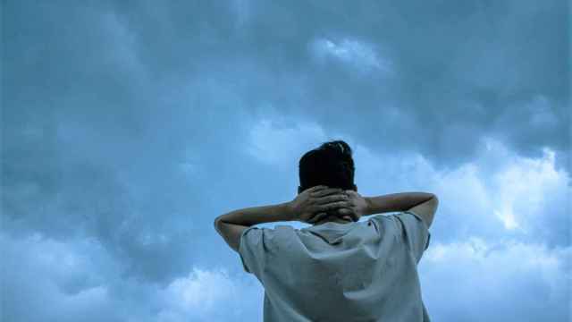 Un joven mira hacia unas nubes que amenazan tormenta.
