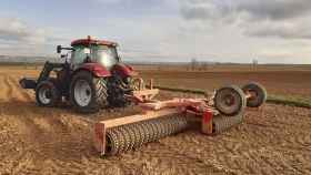 Un tractor en un campo de cultivo de alfalfa en Soria