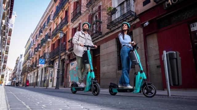 Imagen de archivo de dos personas en patinete eléctrico.