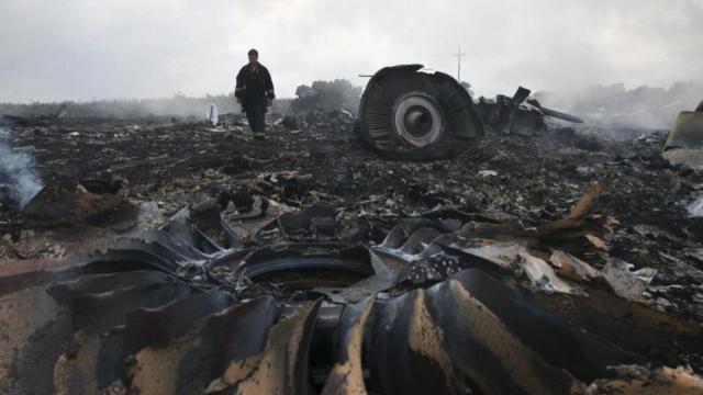 Un miembro del equipo de emergencias ucraniano camina por el lugar donde se estrelló el vuelo MH17, cerca de Grabovo, en la región de Donetsk, el 17 de julio de 2014.