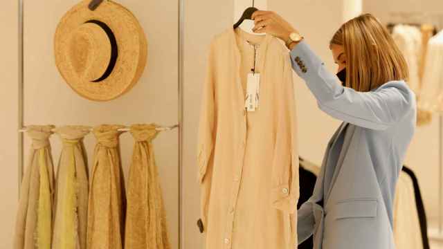 Una dependienta coloca una prenda en el nuevo centro de Inditex con las tiendas de Zara y Stradivarius, en Plaza de España, a 7 de abril de 2022, en Madrid (España).