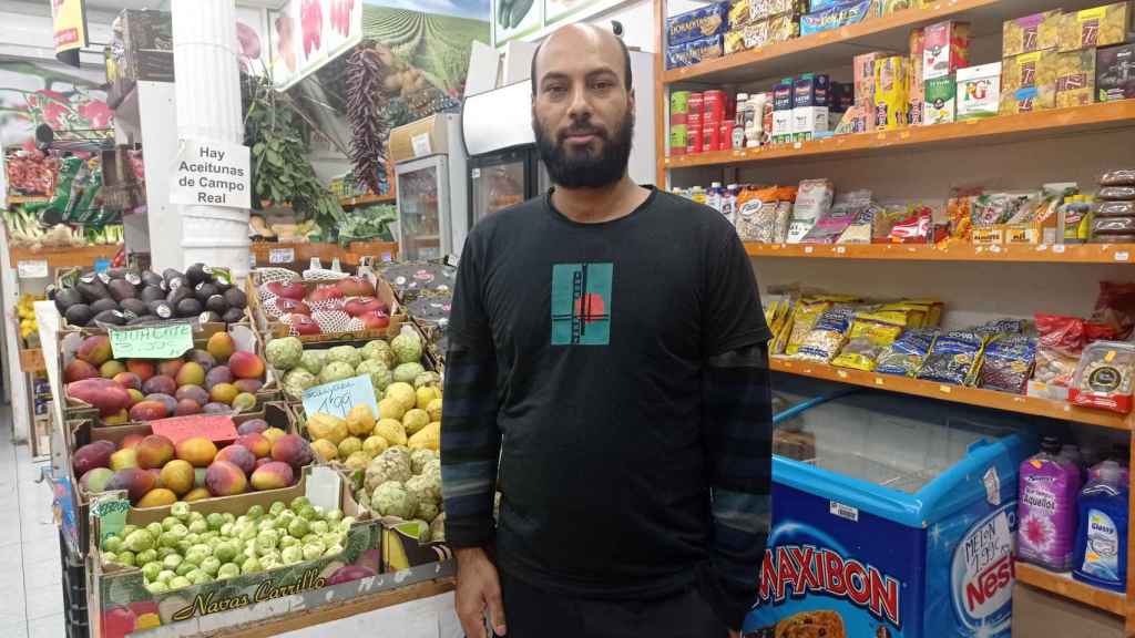 Sumon, un frutero de Bangladés posando en su tienda.