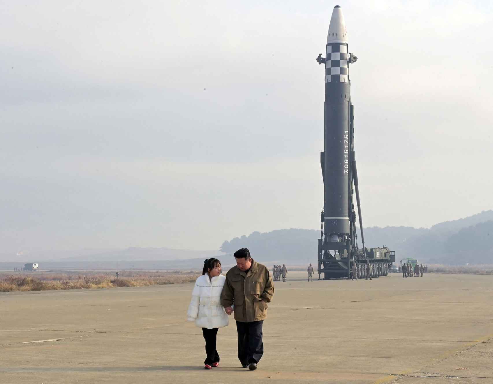 Kim Jong-un camino de la mano junto a su hija por la lanzadera del proyectil antes de su despegue.