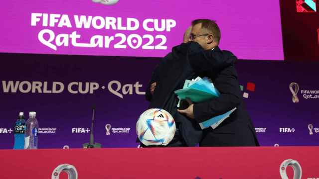 Bryan Swanson se abraza con Gianni Infantino en el centro de prensa del Mundial de Qatar