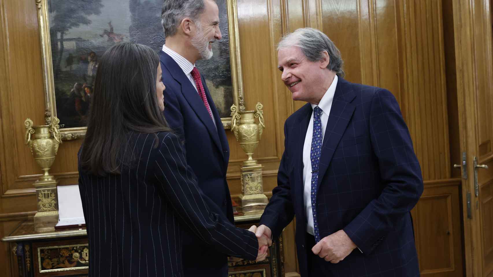 Los Reyes, Felipe VI y Letizia, saludando a un miembro de la reunión en la Zarzuela, este lunes 21 de noviembre.