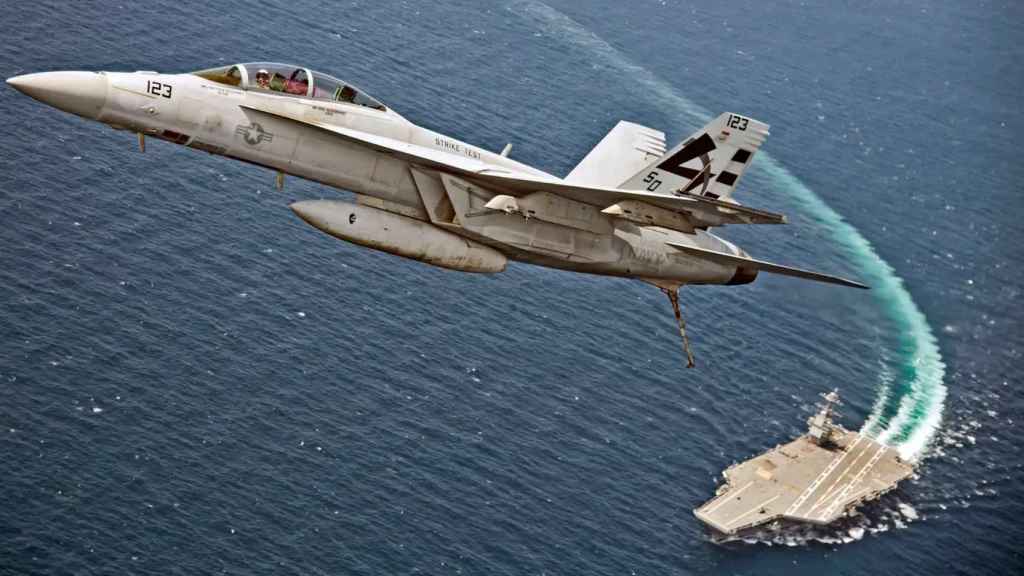 Un caza F-18 y el portaaviones USS Gerald R. Ford