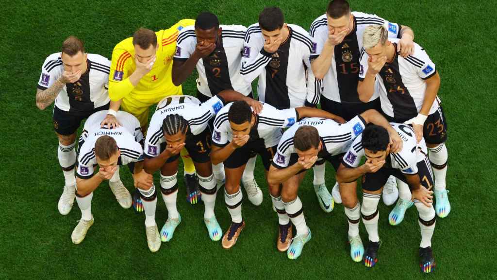Los jugadores de Alemania posan tapándose la boca antes del inicio del partido frente a Japón