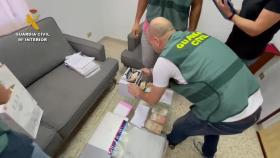 Un guardia civil contando dinero en metálico durante uno de los registros.