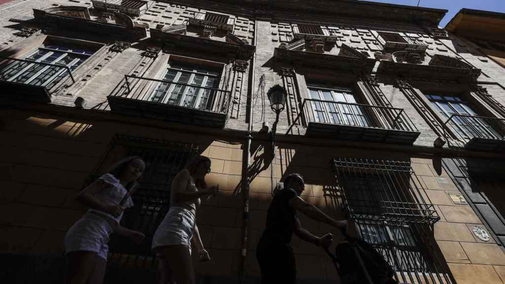 Varios turistas pasan por un bloque de apartamentos en la ciudad de Valencia, en imagen de archivo.