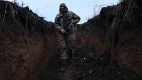 Un soldado ucraniano armado recorre una trinchera.