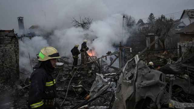 Los bomberos trabajan en el lugar donde se encuentran las casas dañadas por un ataque de misiles rusos