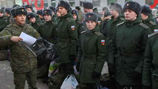 Los reclutas rusos llamados al servicio militar se alinean antes de subir a un tren