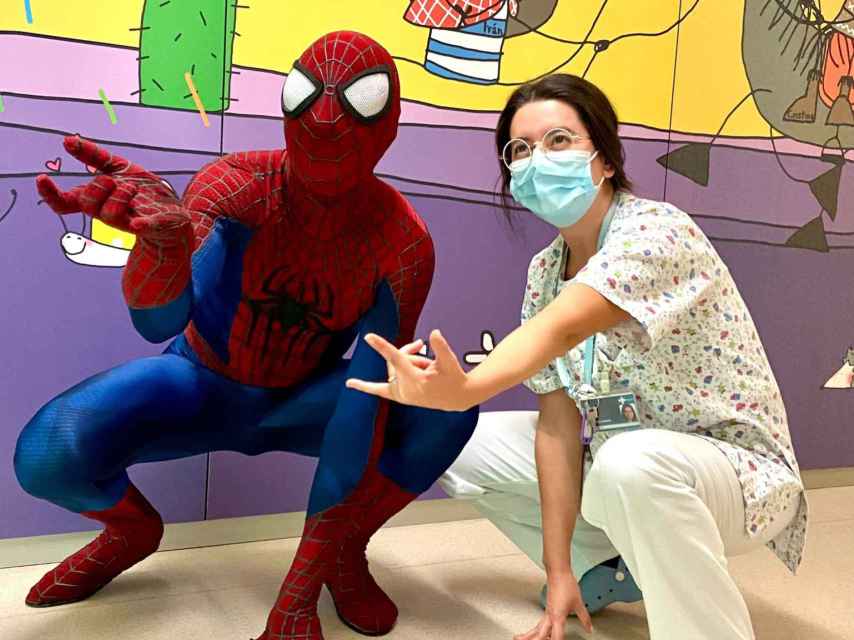 Una enfermera fan de Spiderman posa para que le hagan una foto que inmortalice este momento con el superhéroe